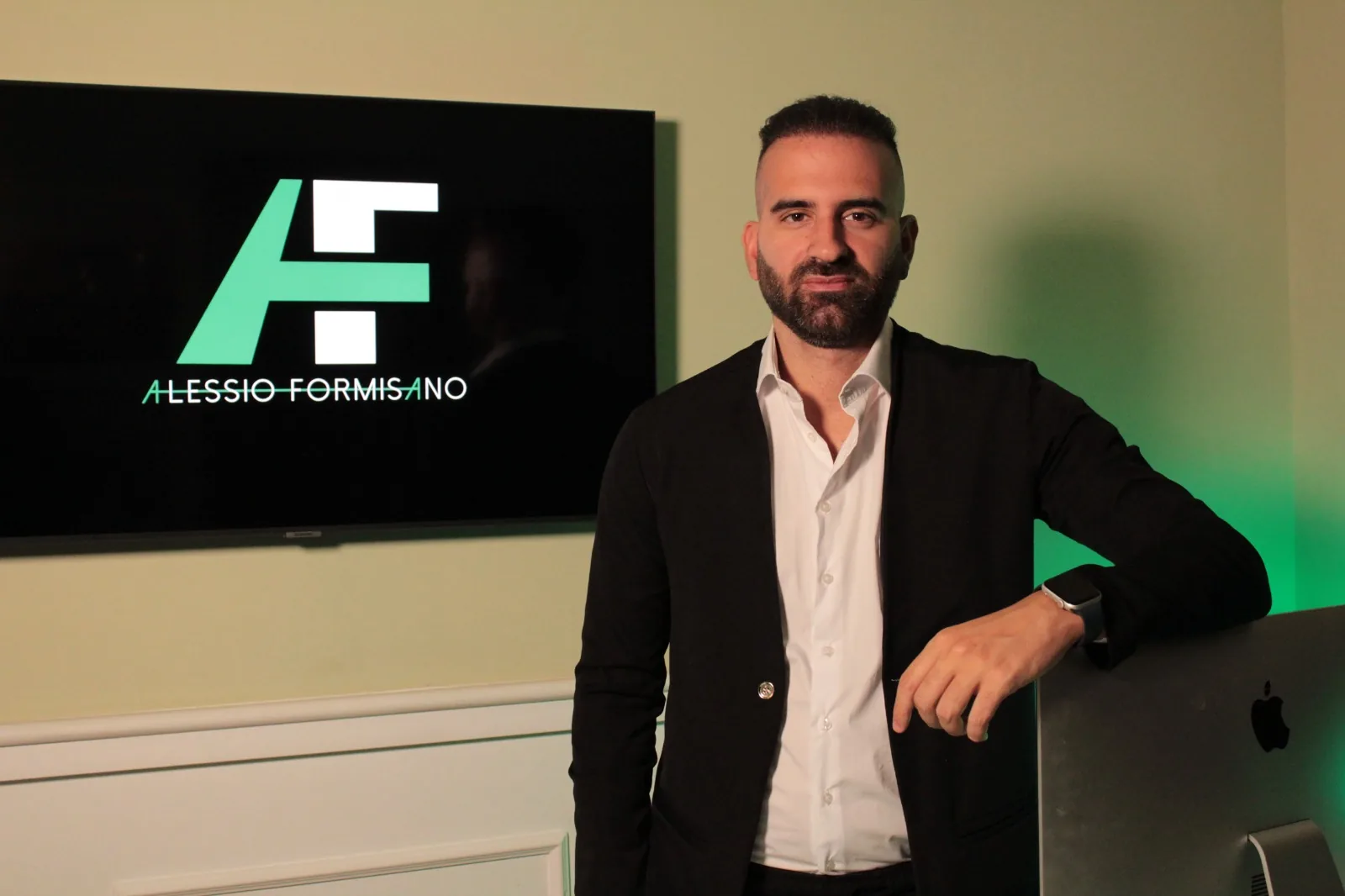 Alessio Formisano nel suo studio, appoggiato alla scrivania